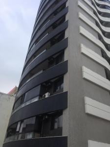 un edificio alto de color gris con ventanas blancas en Exclusivo Quarto e Sala na Praia da Barra em Salvador - Concept House Brazil, en Salvador