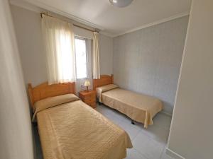 um quarto com 2 camas e uma janela em Apartamentos Portonovo 3000 em Portonovo