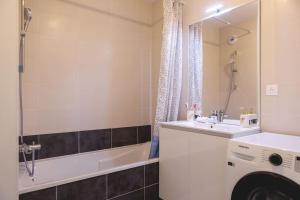 y baño con lavabo y lavadora. en Superbe appartement 2 chambres - parking gratuit en Bourg-en-Bresse