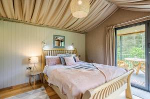 a bedroom with a large bed and a balcony at Riverside Cabins in Shrewsbury