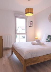 um quarto com uma cama grande e uma janela em Superbe appartement 2 chambres - parking gratuit em Bourg-en-Bresse