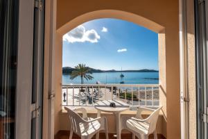 balcón con mesa, sillas y vistas al océano en INNER Niza Paguera, en Paguera