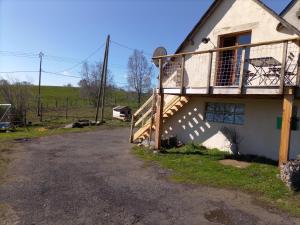 ein Haus mit einem Balkon an der Seite in der Unterkunft Gîte l'estive du Clozel in Besse-en-Chandesse
