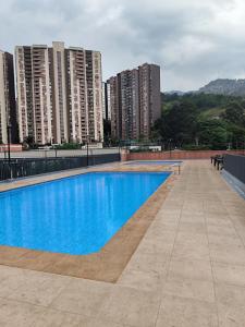 une piscine sur le toit d'un immeuble avec de grands bâtiments dans l'établissement Apartamento Bello amazonia - Medellín, à Bello