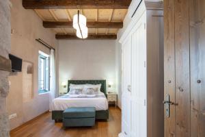 a bedroom with a bed with a green headboard at DOMUS CLODIA, sensing Rethymno's Old Town! in Rethymno Town