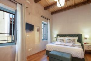 a bedroom with a bed and a tv on the wall at DOMUS CLODIA, sensing Rethymno's Old Town! in Rethymno Town