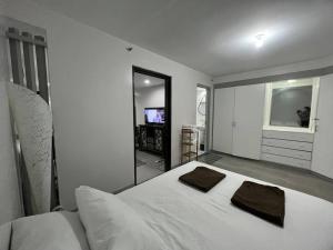 a white bedroom with a large bed and a television at One Bedroom Condo Subic Bay in Morong