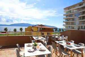 a patio with tables and chairs on a balcony at Ulcas guest huse in Vlorë