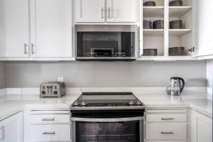 a kitchen with white cabinets and a stove top oven at Santana Row 2br townhouse w pool nr highways SFO-1327 in San Jose
