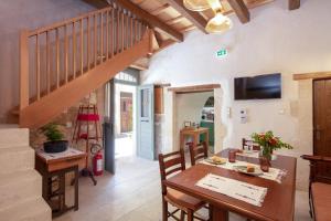 a living room with a wooden table and a staircase at DOMUS CLODIA, sensing Rethymno's Old Town! in Rethymno Town