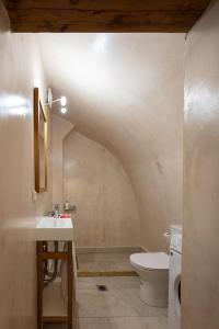 a bathroom with a white toilet and a sink at DOMUS CLODIA, sensing Rethymno's Old Town! in Rethymno Town