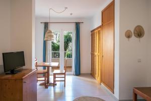 a living room with a television and a table with chairs at INNER Niza Paguera in Paguera