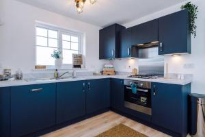 a kitchen with blue cabinets and a sink at Full SKY TV Access 2BR Stylish Apartment in Hough Green