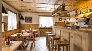 restauracja ze stołami i krzesłami oraz bar w obiekcie Hotel Scherer w mieście Valdaora