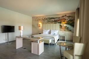 een hotelkamer met een bed en een bureau bij Vila Gale Collection Monte do Vilar in Albernoa