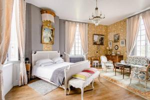 - une chambre avec un lit, une table et des chaises dans l'établissement Château de Montbrault, à Fleurigné