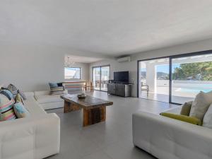 a living room with white couches and a coffee table at Modern Villa with sea views in Sant Josep de sa Talaia