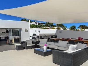 un patio esterno con mobili bianchi e tavolo di Modern Villa with sea views a San Jose de sa Talaia
