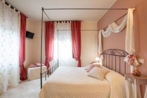 グラダーラにあるAl Borgo Roomsのベッドルーム(天蓋付きベッド、赤いカーテン付)