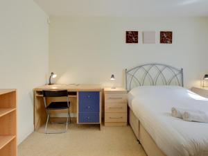 een slaapkamer met een bed en een bureau en een bed bij Pass the Keys Spacious apartment for 2 free parking in Manchester