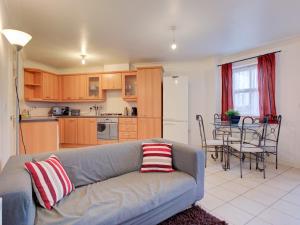 een woonkamer met een bank en een keuken met een tafel bij Pass the Keys Spacious apartment for 2 free parking in Manchester
