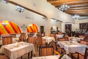 Malaga Hotel في Panorama: مطعم فيه طاولات وكراسي في الغرفة