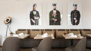 a restaurant with four pictures of people on the wall at BASE II - Das Bed & Breakfast bei Basel (Lörrach) in Lörrach