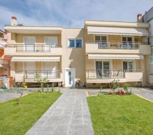 a large house with a lawn in front of it at Myrsini’s sea view apartment in Nea Peramos