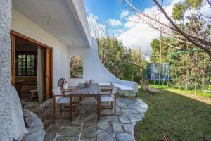 een patio met een tafel en stoelen in een tuin bij A family paradise! in Áyios Andréas