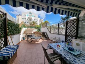 a patio with a table and chairs on a balcony at Alloggio in residence con pontile privato e accesso diretto al mare in Santa Marinella