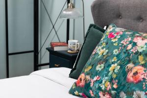 uma cama com uma almofada floral e um candeeiro sobre uma mesa em Crookes House em Weston-super-Mare