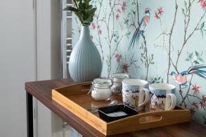 una bandeja de madera con tazas y un jarrón sobre una mesa en Crookes House, en Weston-super-Mare