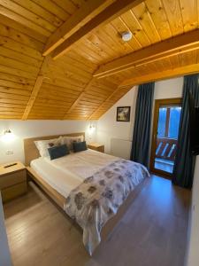 1 dormitorio con 1 cama grande y techo de madera en Pintea Chalet, en Baia-Sprie