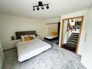 - une chambre avec un lit, un miroir et un escalier dans l'établissement W27B - Alla Prima, Super villa au cœur de Giverny, à Giverny