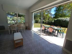 - un salon avec une table, des chaises et des portes coulissantes en verre dans l'établissement Pyla-sur-mer maison 2 chambres et jardin - à 400m des plages, à La Teste-de-Buch