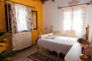 1 dormitorio con 1 cama blanca y 2 ventanas en Sunshine Villa en Vasilikós