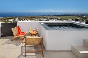 un balcone con una piccola piscina con sedie e un tavolo di Venus Sunrise Suites & Villas a Vourvoúlos