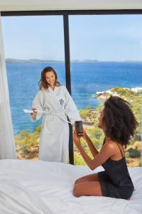 a woman taking a picture of a woman sitting on a bed at TRS Ibiza Hotel - Adults Only in San Antonio