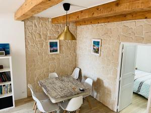 a dining room with a stone wall and a table and chairs at Duplex La Ciotat - superbe 85 m2 - 6 pers - 3 chambres - Climatisation - Vue mer et proche du vieux port La Ciotat in La Ciotat +12 photos