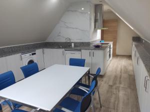 kuchnia ze stołem i niebieskimi krzesłami w obiekcie Casa da Escuela w mieście Caldas de Reis +17 zdjęć