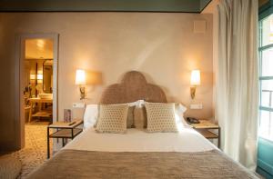 a bedroom with a large white bed with pillows at Hospes Las Casas Del Rey De Baeza in Seville