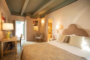 1 dormitorio con 1 cama grande y escritorio con lámpara en Hospes Las Casas Del Rey De Baeza, en Sevilla