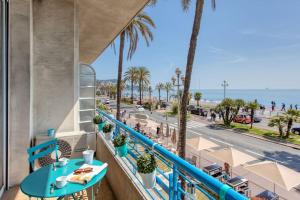 balcón con mesa azul y vistas a la playa en L14 2P Promenade Vue Mer climatisé, spacieux/ Balcon, en Niza