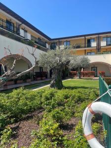 un arbre dans une cour à côté d'un bâtiment dans l'établissement Le Terrazze sul Lago Hotel & Residence, à Padenghe sul Garda