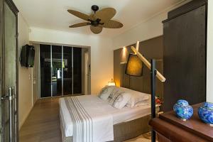 Schlafzimmer mit einem Bett und einem Deckenventilator in der Unterkunft Private pool & sea view residence in Saronida