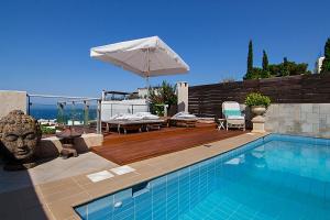 eine Villa mit einem Pool und einem Sonnenschirm in der Unterkunft Private pool & sea view residence in Saronida