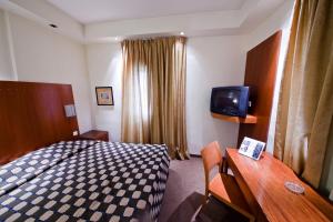 um quarto de hotel com uma cama e uma TV em SeaNet Hotel By AFI Hotels em Tel Aviv