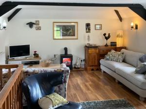 a living room with a couch and a tv at Kielder Cottage - E3533 in Kielder