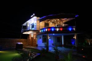 nocny widok na dom z niebieskimi światłami w obiekcie Goroomgo Bottom Up Villa Swimming Pool Bhubaneswar w mieście Bhubaneswar
