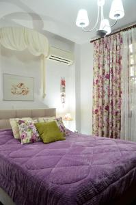 a purple bed with a purple comforter in a bedroom at Antalia Home in Kalamata